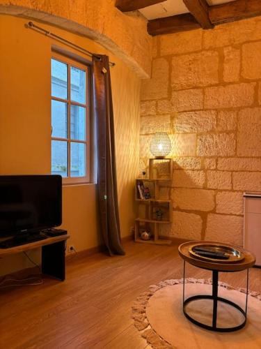 un salon avec une table et une télévision dans l'établissement La Tour - Hyper Centre - Place du Palet, à Angoulême
