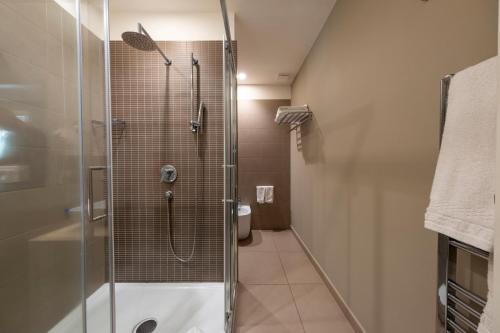 a bathroom with a shower with a glass door at Airone City Hotel in Catania