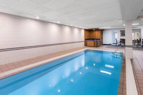 a large swimming pool in a gym with a pool at Grif5 Modern 2BR apartment with Parking in Kingston 
