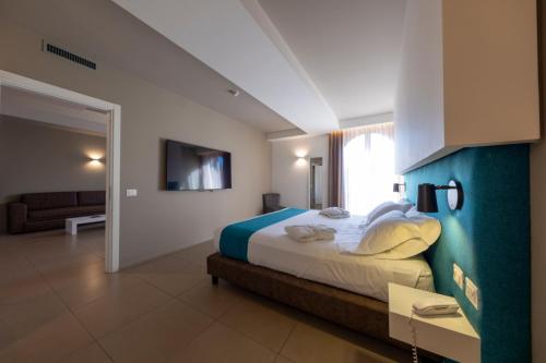 um quarto com uma cama grande e um sofá em Airone City Hotel em Catânia