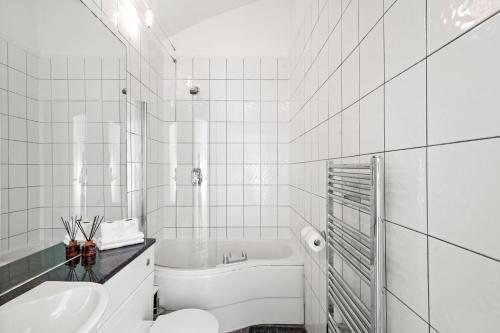 a white bathroom with a toilet and a sink at Stunning 3 Bed in Putney - Parking in London