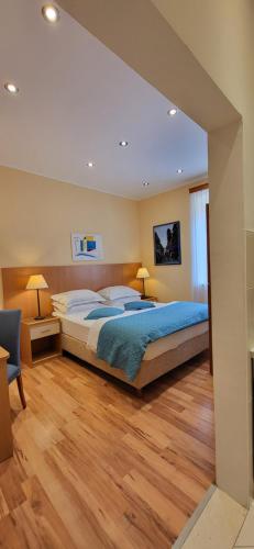 a bedroom with a large bed and a wooden floor at Apartments Miljas 1 in Dubrovnik