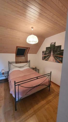 a bedroom with a bed and a ceiling at Gîtes de Maner Ster - Le Frêne Piscine ou Le Chêne Piscine et Spa privatif in Cléden-Poher