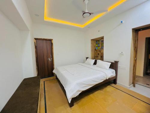 um quarto com uma cama branca num quarto em Hotel Golden Garh em Jaisalmer