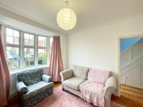 a living room with a couch and a chair and window at Greater London House with excellent transport in Forest Hill