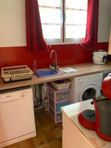 cocina con fregadero y lavadora en Maison indépendante à proximité des lacs en Saint-Pierre-Bellevue
