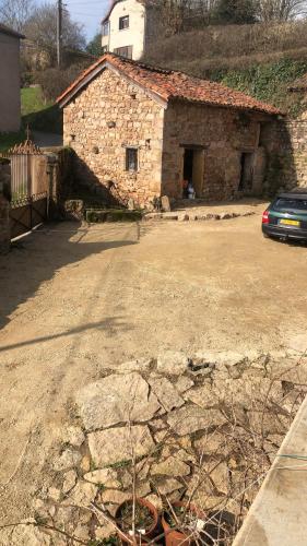 a car parked in front of a stone building at Ferme Fleurie in Bergesserin
