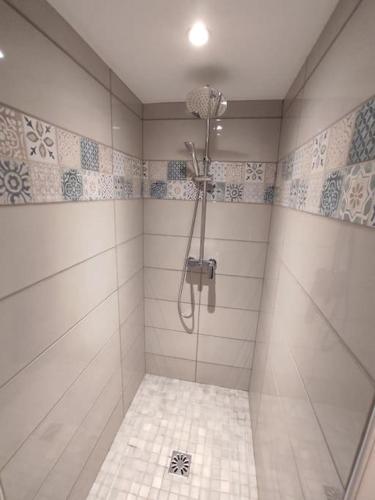 une salle de bain avec douche carrelée de blanc dans l'établissement Maison typique - marché, port et la plage à 200m, au Pouliguen