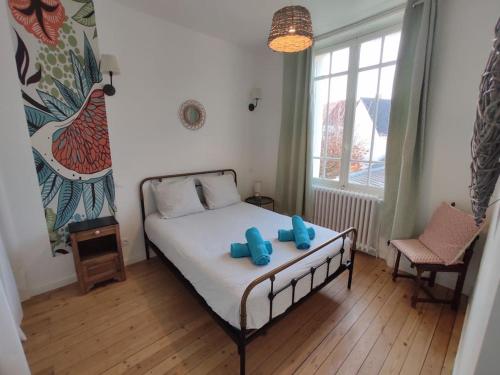 une chambre avec un lit avec deux oreillers bleus dessus dans l'établissement Maison typique - marché, port et la plage à 200m, au Pouliguen