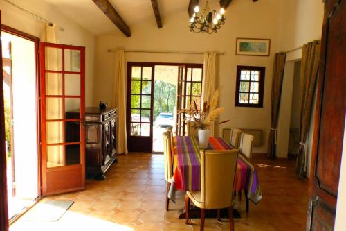 une salle à manger avec une table, des chaises et une porte dans l'établissement Family cottage facing the sea, à Six-Fours-les-Plages