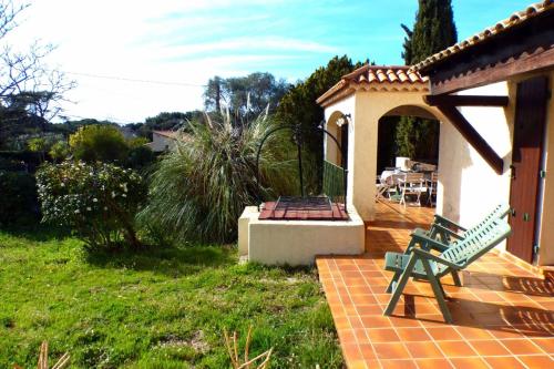 une maison avec un banc vert sur une terrasse dans l'établissement Family cottage facing the sea, à Six-Fours-les-Plages