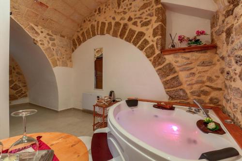 uma banheira num quarto com uma parede de pedra em Casa Relax em Mesagne
