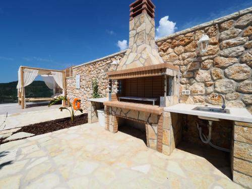 an outdoor kitchen with a stone wall at PARGA Villas Collection in Parga
