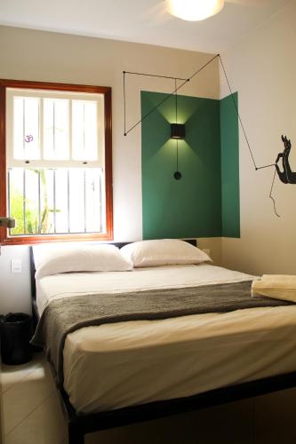 a bedroom with a large bed with a green wall at Reserva 69 Hostel in Sao Paulo