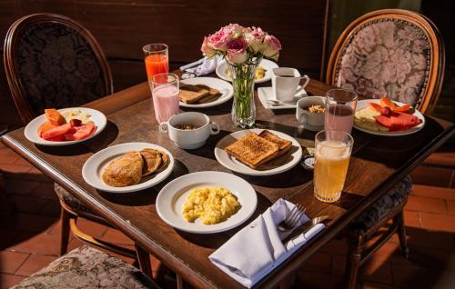 a table with plates of breakfast food on it at AVANTI HOTEL & CONVENTION CENTER in Cochabamba