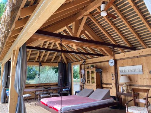 Saint-AndiolにあるMas de la Mareのベッドとテーブル付きの広い木製の部屋