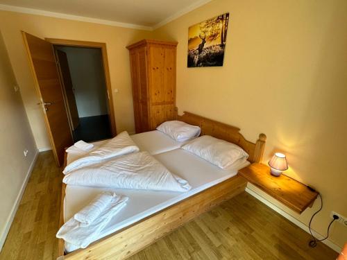 two beds in a bedroom with a lamp on a table at Familienfreundliche Ferienwohnung im Thierseetal, FeWo 11 in Thiersee