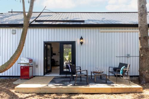 a patio with chairs and a table in front of a building at The Barns of Brighton Near Prince Edward County in Brighton
