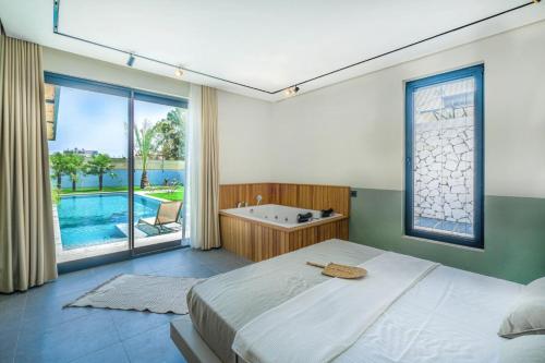een slaapkamer met een groot bed en een bad bij Villa Vio 2 in Fethiye