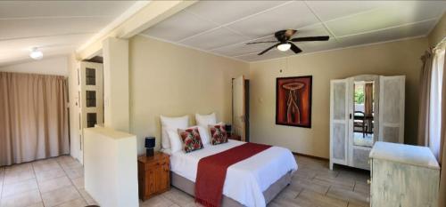 a bedroom with a bed and a ceiling fan at Seacastle Guesthouse in Port St Johns
