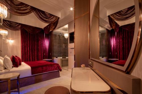 Paris j'Adore Hotel & Spa في باريس: غرفة نوم بسرير ومرآة كبيرة