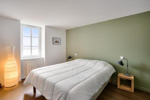 une chambre avec un grand lit et une fenêtre dans l'établissement Vue exceptionnelle - Accès privé front de mer, à La Ville-ès-Nonais