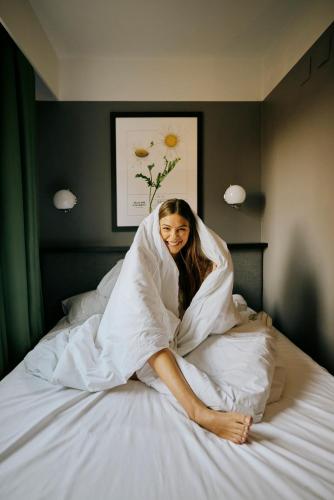 a woman wrapped in a blanket on a bed at Hotel Malcom and Barret in Valencia