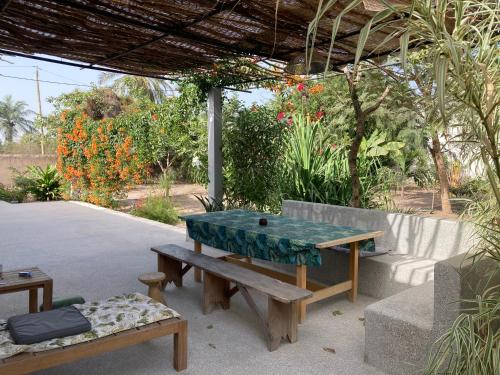 a picnic table and bench under a pavilion at Villa Soforal in Cap Skirring