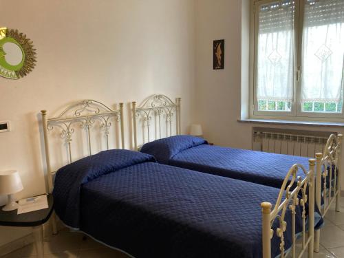 2 letti con lenzuola blu in una camera da letto di Aroma Di Mare a Lido di Ostia