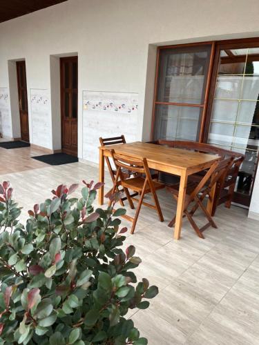 una mesa de madera y sillas en un patio en Cicáskacus Vendégház en Matrafured