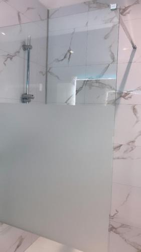 La salle de bains est pourvue d'une douche et d'une paroi en verre. dans l'établissement La Boissiere, à Avrillé