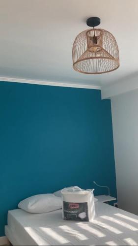 Cette chambre comprend un lit avec un mur bleu et une lampe. dans l'établissement La Boissiere, à Avrillé