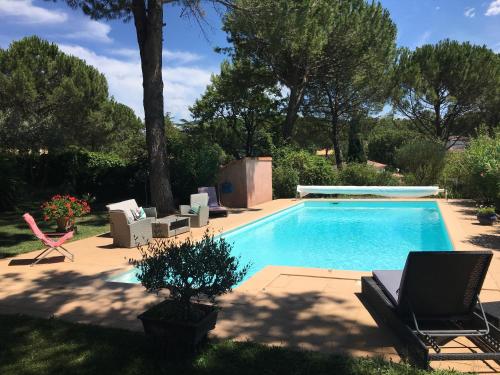 une piscine avec deux chaises longues et une table dans l'établissement Bel Appartement indépendant lumineux - St-Maximin, à Saint-Maximin-la-Sainte-Baume
