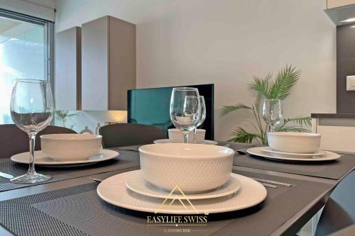 a table with two wine glasses and a bowl on it at Avorio Wonderful and Modern Loft in Bellinzona -By EasyLife Swiss in Bellinzona