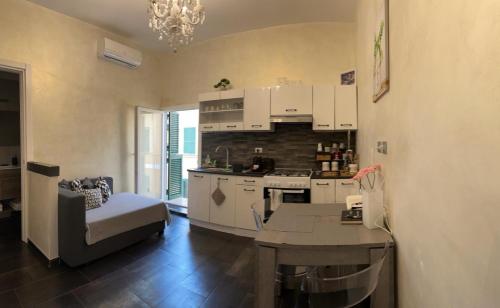 eine Küche und ein Wohnzimmer mit einem Tisch und einem Sofa in der Unterkunft Palms House in Rom