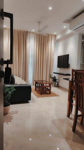 a living room with a couch and a table at Trendy1BR+smart kitchen +Living room+1.5 toilets in Mumbai
