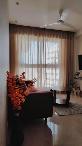 a living room with a couch and a large window at Trendy1BR+smart kitchen +Living room+1.5 toilets in Mumbai