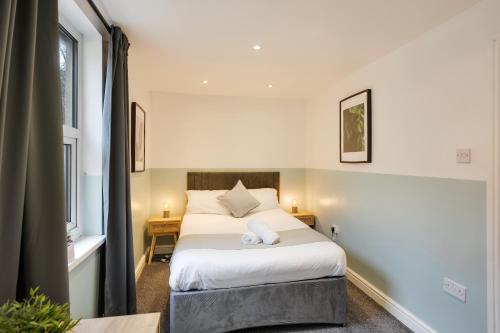 1 dormitorio con cama y ventana en 4 Person Modern Apartment Nr City Centre, en Cardiff