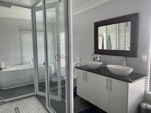 a bathroom with two sinks and a tub and a mirror at Oaktree in Ermelo