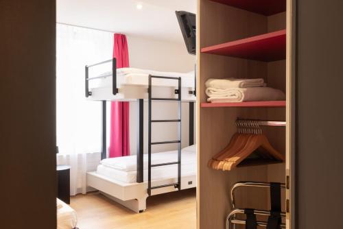 a small room with a bunk bed in a room at Fred Guest House Hauptbahnhof - Mobile Check-in in Zürich