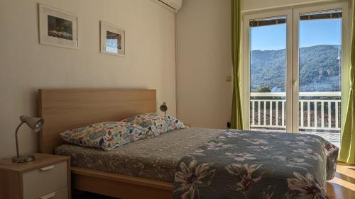 ein Schlafzimmer mit einem Bett und einem großen Fenster in der Unterkunft Apartments Marinko in Stari Grad