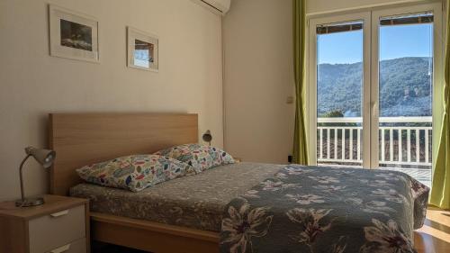 a bedroom with a bed and a large window at Apartments Marinko in Stari Grad