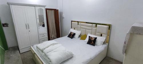 een slaapkamer met een bed met witte lakens en kussens bij Ramashray - Spiritual कुटिया in Ayodhya
