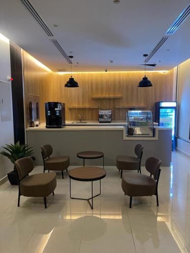 a lobby with tables and chairs and a kitchen at شقق الورود بارك in Al Mikhlaf