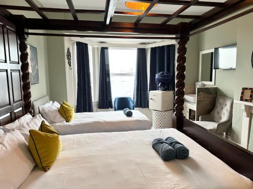 Habitación de hotel con 2 camas y ventana en La Di Da Hotel beach town en Bournemouth