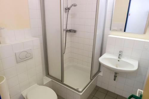 a bathroom with a shower and a toilet and a sink at Jugendherberge Friedrichstadt in Friedrichstadt