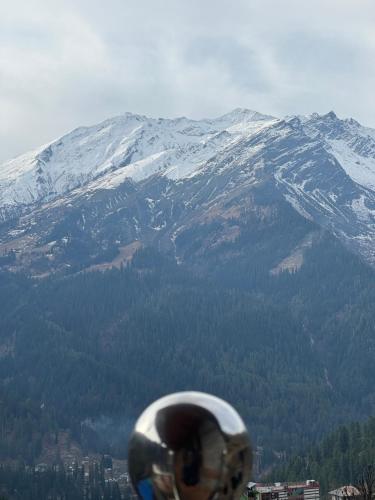 a view of a snow covered mountain from a persons hand at Cafekush tosh in Tosh