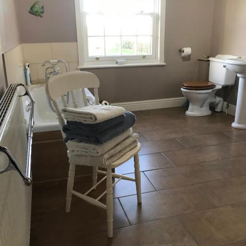 a pile of towels sitting on a chair in a bathroom at Close House Cottage in York