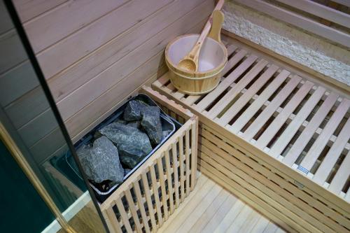 a soak room with a bucket and rocks on a deck at NG Prestige - Nain I Suite Spa Privatif Premium I Jacuzzi - Sauna - Netflix - Projecteur in Roubaix