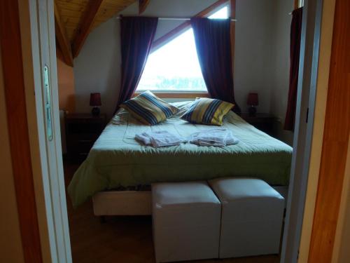a bedroom with a bed with a window at Apart Don Felipe in El Calafate